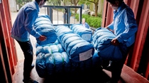 Three BASF employees loading a truck with mosquito nets Three BASF employees loading a truck with mosquito nets