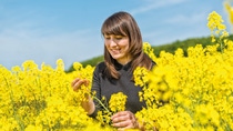 Young female farmer in a oilseed rape field