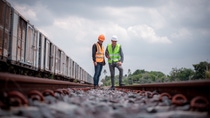 Engineer under discussion inspection and checking construction process railway switch and checking work on railroad station .Engineer wearing safety uniform and safety helmet in work.