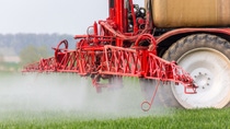 Spraying machine working on the green field Spraying machine working on the green field