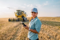 La granjera sostiene una tableta digital en un campo agrícola. Agricultura inteligente La granjera sostiene una tableta digital en un campo agrícola. Agricultura inteligente