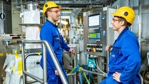 Two production workers have a conversation with each other Two production workers have a conversation with each other