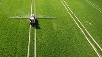 Two field sprayers working on a green field. Two field sprayers working on a green field.