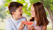 Two kids eating watermelon