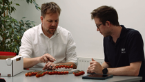 Two people assessing the quality of tomatoes