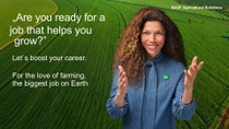 A woman in front of a field. The text reads: Are you ready for a job that helps you grow?