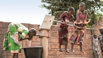 Young Girls Pumping Water At A Public Borehole in West Africa