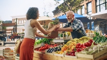 Customer buys goods at the weekly market Customer buys goods at the weekly market