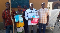 Community members in Burkina Faso with holding mosquito nets
