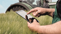 Hombre apuntando a la tableta con el tractor en el fondo BASF Argentina Hombre apuntando a la tableta con el tractor en el fondo BASF Argentina