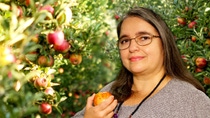 Diana Orchard standing in front of apple trees