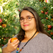 Dr. Diana Londoño in front of apple trees holding an apple Dr. Diana Londoño in front of apple trees holding an apple