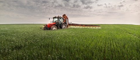 AR Tractor rociando pesticidas en campos de trigo