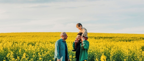 Un padre lleva a su hijo al hombro junto a su abuelo en un campo de colza Un padre lleva a su hijo al hombro junto a su abuelo en un campo de colza