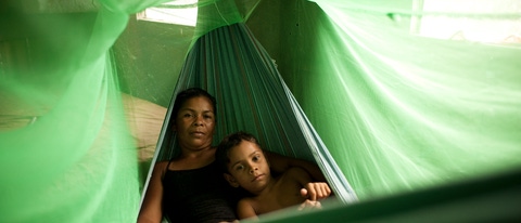 Mulher e criança deitados na rede verde BASF Brasil Mulher e criança deitados na rede verde BASF Brasil
