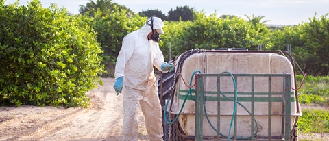 Agricultor con EPP aplicando fungicida Agricultor con EPP aplicando fungicida