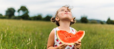 Chica comiendo sandía al aire libre