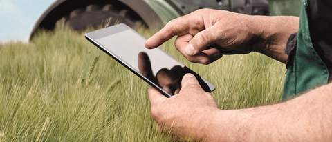 Un hombre usando una tableta en una granja Un hombre usando una tableta en una granja