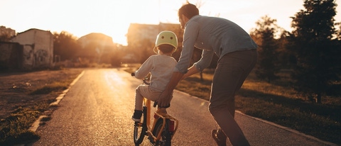 Father helping his child to drive a bicycle Father helping his child to drive a bicycle