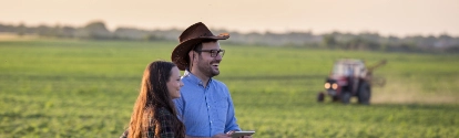 Un hombre y una mujer en el campo utilizando tecnología en una plantación