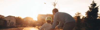 Father helping his child to drive a bicycle