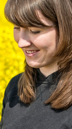 Young female farmer in a oilseed rape field working with a tablet PC