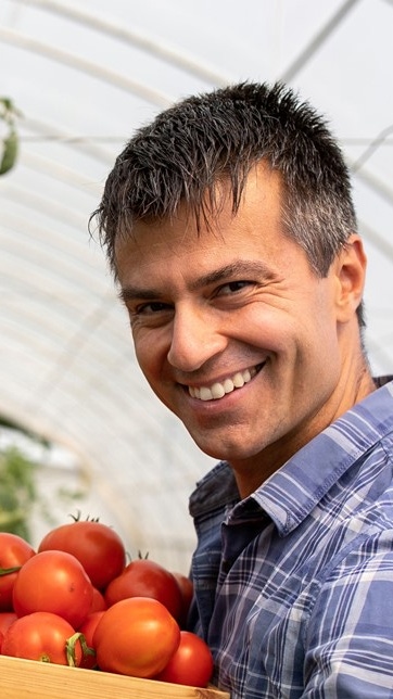 A man holding a basket of tomatoes