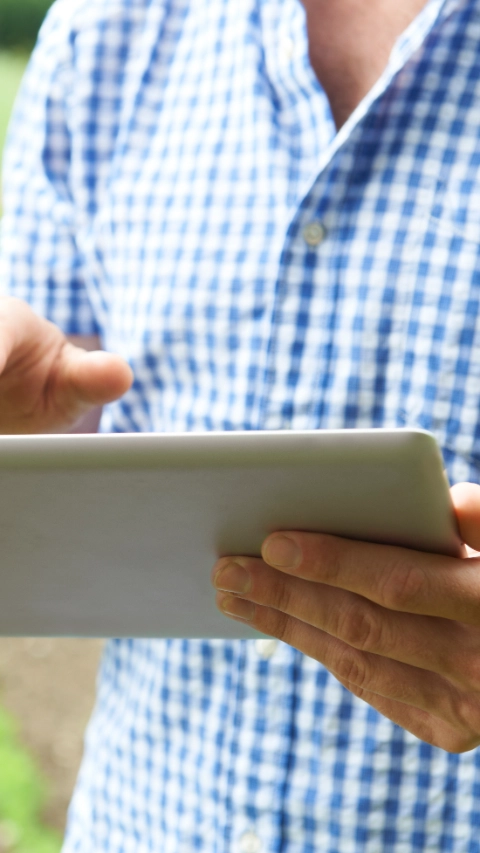 Close Up Of Farmer Using Digital Tablet On Organic Farm