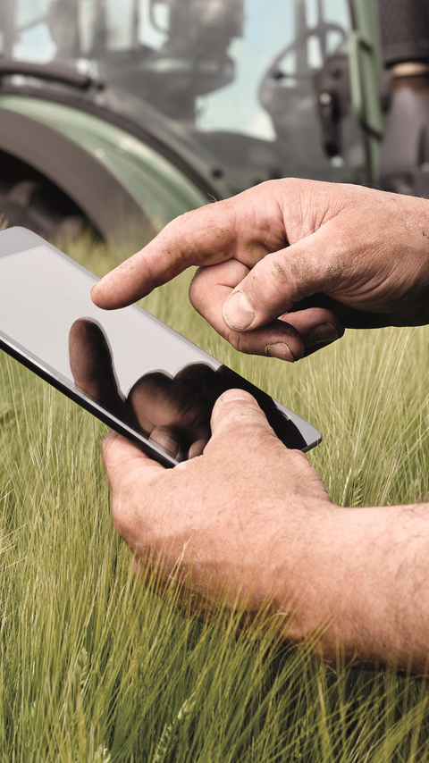 Un hombre usando una tableta en una granja